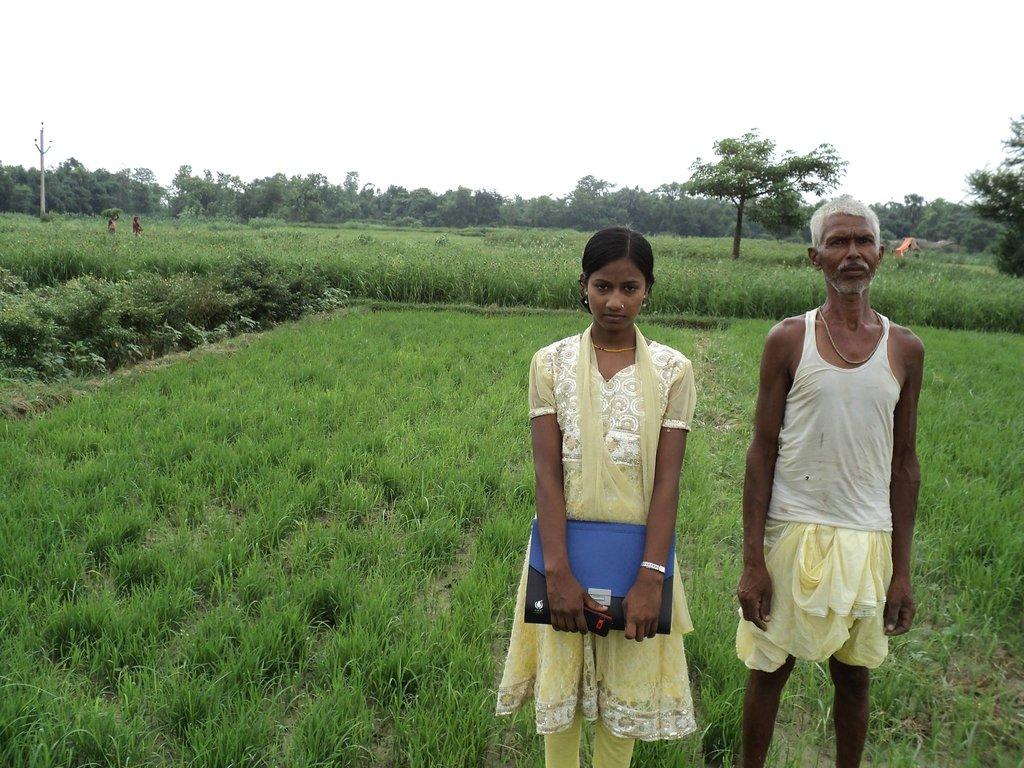 Farmer and young girl standing in a field